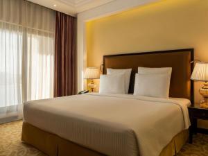 a hotel room with a large bed with white pillows at Pullman Resort Al Marjan Island in Ras al Khaimah +173 photos
