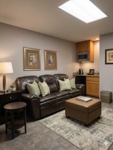 a living room with a leather couch and a table at Apple Tree Inn in Independence