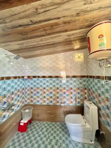 a bathroom with a toilet and a sink at Orchard Valley Resort in Mai Jūbar