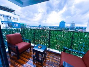 a balcony with two chairs and a table on a building at SPOTLESS HOSTEL, WESTLANDs Orc in Nairobi
