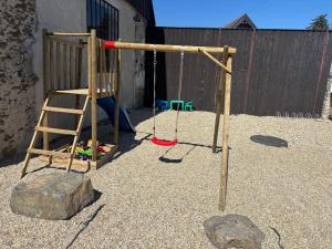 a playground with a wooden swing set and a rock at Stodola Lesůňky in Lesŭňky