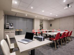 a conference room with a table with a laptop on it at Mercure Oostende in Ostend