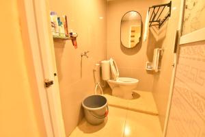 a small bathroom with a toilet and a mirror at Elle Maya Sari Residence in Kotabaru