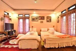 a bedroom with two beds and a flat screen tv at Elle Maya Sari Residence in Kotabaru