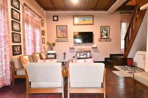 a living room with a table and chairs and a tv at Elle Maya Sari Residence in Kotabaru