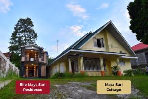 a small house with a balcony and a house at Elle Maya Sari Residence in Kotabaru