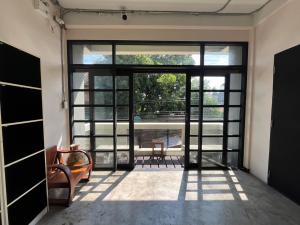 a room with a large glass door with a table and chairs at BNK89 Hostel in Bangkok