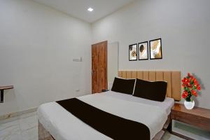 a bedroom with a bed and a vase with flowers at Super Collection O Dalhousie Square Kolkata Formerly G.N Palace in Calcutta Bara Bazar