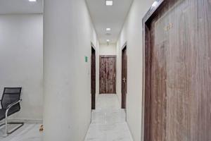 a hallway with a chair and a hallway with doors at Super Collection O Dalhousie Square Kolkata Formerly G.N Palace in Calcutta Bara Bazar