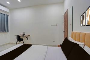 a bedroom with a bed and a desk with a chair at Super Collection O Dalhousie Square Kolkata Formerly G.N Palace in Calcutta Bara Bazar