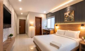 a bedroom with a large white bed and a desk at Harvey's Suites in Gachibowli