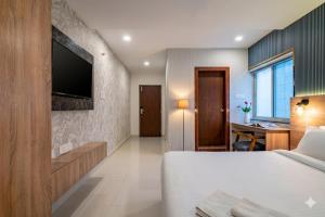 a bedroom with a bed and a desk and a television at Harvey's Suites in Gachibowli