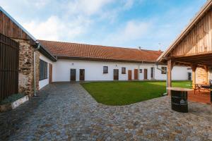 a courtyard of a white building with a grass yard at Stodola Lesůňky in Lesŭňky