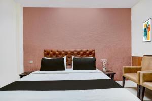 a bedroom with a large bed and a red wall at Collection O Haridwar Railway Station Formerly Le Central in Haridwār
