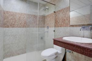a bathroom with a toilet and a sink and a shower at Collection O Haridwar Railway Station Formerly Le Central in Haridwār