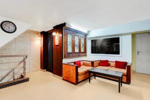 a living room with a couch and a table and a clock at Super Hotel O by OYO Clock Tower Ludhiana Formerly Greatwall in Ludhiana