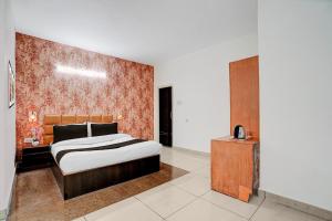 a bedroom with a bed and a wooden cabinet at Super Hotel O by OYO Clock Tower Ludhiana Formerly Greatwall in Ludhiana