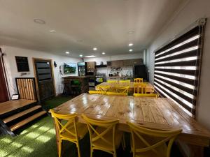 a dining room with a wooden table and yellow chairs at El Refugio in Puerto Natales