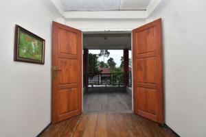 an empty room with two doors and a view of a porch at Maya Sari Cottage Pandai Sikek in Kotabaru +19 photos