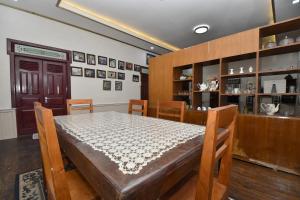 a dining room with a table and chairs and a shelf at Maya Sari Cottage Pandai Sikek in Kotabaru