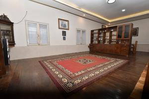 a room with a red rug on a wooden floor at Maya Sari Cottage Pandai Sikek in Kotabaru