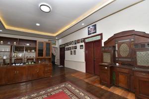 a large room with wooden cabinets and a room with a rug at Maya Sari Cottage Pandai Sikek in Kotabaru
