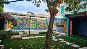 a mural on the side of a building with a tree at El Cacique Villeta Hostal in Villeta