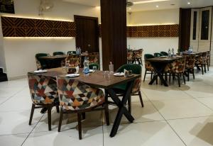 a dining room with wooden tables and chairs at Hotel Gharana Tree in Gaya