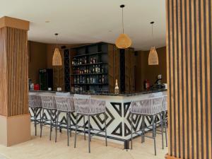 a bar with bar stools in a room at Pullman Lubumbashi Grand Karavia. in Lubumbashi