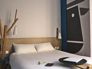 a bedroom with a bed with a desk and a keyboard at ibis Styles Moulins Centre in Moulins +87 photos