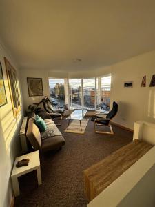a living room with a bed and a couch and chairs at El Refugio in Puerto Natales