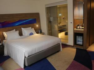 a bedroom with a large bed and a bathroom at Novotel Taiping in Taiping