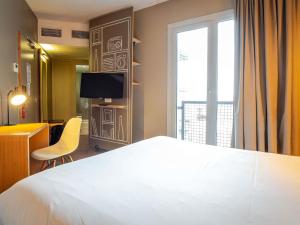 a hotel room with a large bed and a window at ibis Bordeaux Centre Gare Saint Jean Euratlantique in Bordeaux