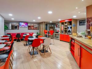 a restaurant with red cabinets and tables and chairs at ibis Bordeaux Centre Gare Saint Jean Euratlantique in Bordeaux