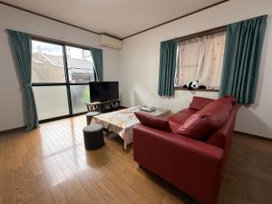 a living room with a red couch and a table at Hana88 in Otsu
