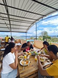 a group of people sitting at a table eating food at Complejo Campestre Salome Cabañas & Hotel in Calima
