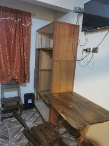 a room with a wooden table and a tv at Hostal Salome in Cochabamba