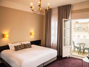 a bedroom with a bed and a window and a table at Hôtel Mercure Bayonne Centre Le Grand Hotel in Bayonne +94 photos