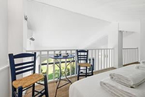 a bedroom with a bed and two chairs and a table at The Garden Maisonette in Gouvia +34 photos