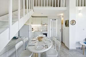 a white dining room with a white table and chairs at The Garden Maisonette in Gouvia
