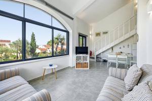 a living room with two couches and a tv at The Garden Maisonette in Gouvia