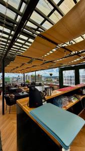 a restaurant with a bar with tables and windows at SPOTLESS HOSTEL, WESTLANDs Orc in Nairobi