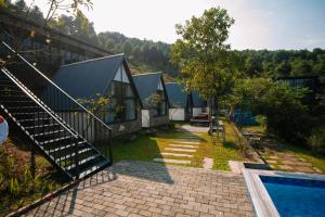 a house with a pool and stairs next to it at Daisy Queen Village Ba Vì in Yên Cư
