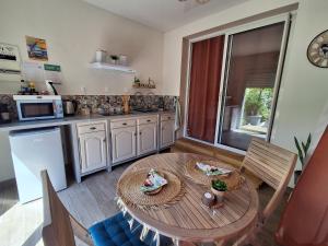 a kitchen with a wooden table and a dining room at La Parenthèse 2 Rêves in Saint-Joseph