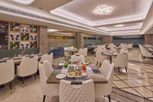 a restaurant with tables and chairs in a room at Regenta Devarayah Tirupati in Tirupati