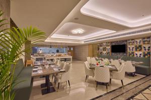 a restaurant with a long table and chairs at Regenta Devarayah Tirupati in Tirupati