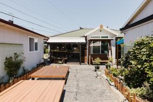 a patio with a wooden bench and a building at Pyeonanhan Guesthouse in Hamdŏng-ni