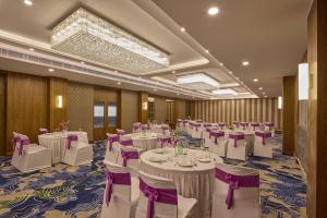 a banquet hall with white tables and purple chairs at Regenta Devarayah Tirupati in Tirupati +66 photos