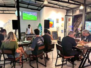 a group of people sitting at tables in a restaurant at The Breeze Hostel in Haad Rin +9 photos