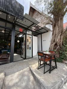 a table and a chair in front of a building at The Breeze Hostel in Haad Rin